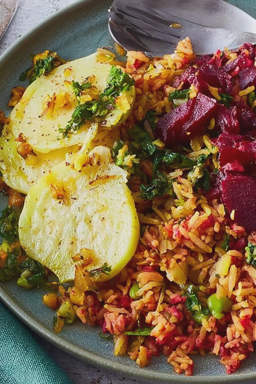 Ofenkohlrabi mit Rote-Bete-Gewürzreis auf einem Teller, garniert mit Pistazien und Zitrone.